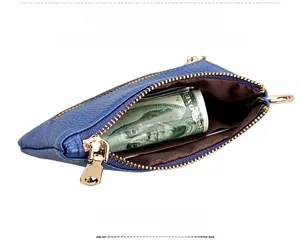Detailed view of blue litchi grain leather coin purse with gold zipper and cash inside