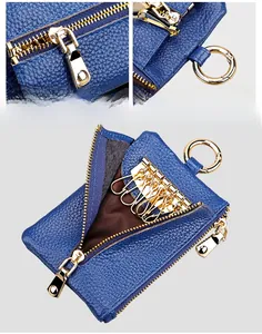 Detail of blue lychee grain leather key pouch with gold rings and dual zipper closure
