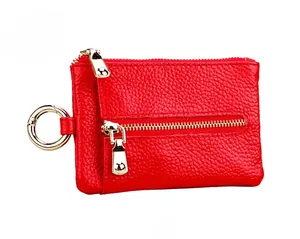 Detail of red lychee grain leather key pouch with dual gold zippers and metal ring
