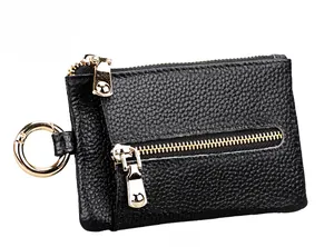 Detail of black lychee leather coin purse featuring dual gold zippers and spring clasp