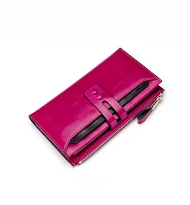 Detail view of rose red oil wax leather wallet with black buckle strap and golden zipper