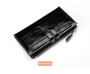 Top view of a black oil wax leather wallet featuring dual decorative buckles and gold zipper