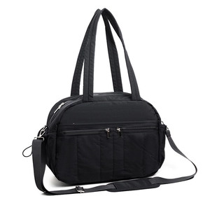 Detail of black travel bag with double front zippers and adjustable padded shoulder strap