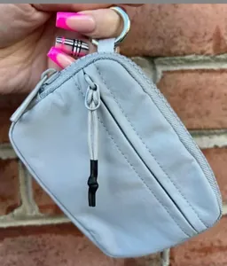Close-up of waterproof nylon mini backpack keychain with silver metal ring and zippers