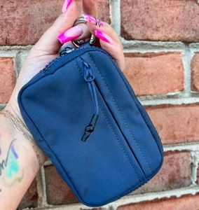Detail of dark blue waterproof nylon mini wallet with zippers and metallic key hook