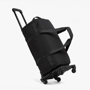 Detail view of the black cylindrical travel duffel bag with portable folding trolley cart