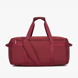 Detail of burgundy travel bag featuring durable fabric and adjustable padded shoulder strap
