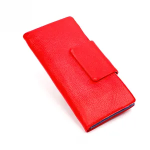 Detail of red leather long wallet for women featuring classic pebbled grain and flap buckle