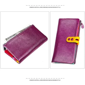 Detalle de cartera de cuero morado con hebilla amarilla y cierre de cremallera duradero
