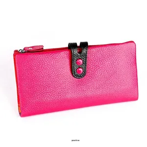 Detalle de cartera de piel granulada en color rosa con hebilla negra y cremallera
