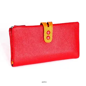 Detalle de billetera larga de cuero rojo con patrón de lichi y hebilla de contraste