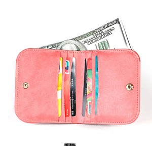Dettaglio dell'interno di un portafoglio in pelle rosa con scomparti per carte e banconote