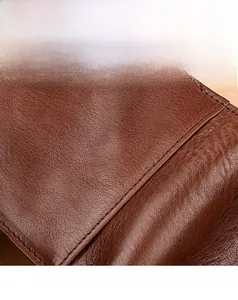 Detailed macro view of genuine brown leather texture and fine stitching on the wallet