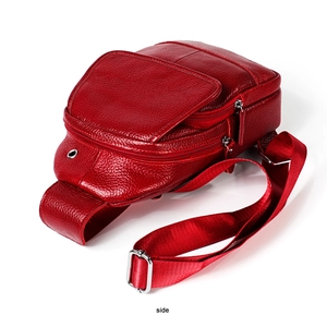 Side view of red pebble leather chest bag showing multiple silver zip compartments