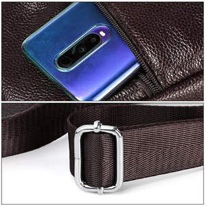 Detail of dark brown pebble leather sling bag with silver metal buckle and phone compartment