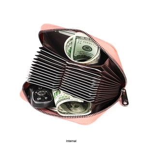 Detalle de cartera de cuero rosa con ranuras interiores y espacio para llaves