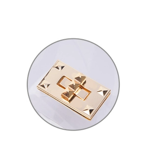 Macro shot of polished champagne gold metal clasp with stud details on transparent bag