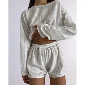 Detail of white long sleeve top and high-waisted shorts with breathable hollow texture