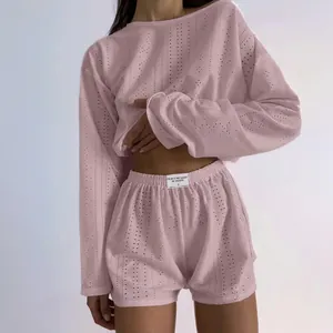 Close-up of pink knit loungewear set featuring delicate pointelle texture and logo label