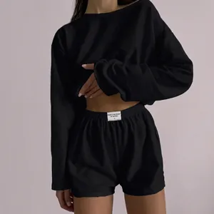Close-up of black two-piece lounge set showing textured fabric and elastic waistband