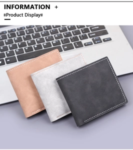 Tre portafogli bifold in marrone e grigio con cuciture a contrasto su sfondo laptop
