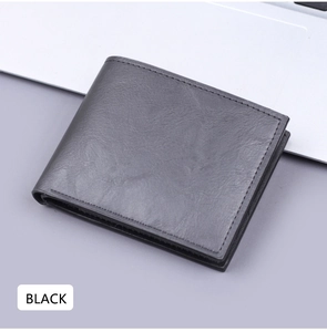 Close-up of black bifold wallet showing leather texture and stitching on office desk