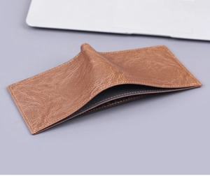 Close-up of vintage brown leather men's wallet with distinct yellow stitching details