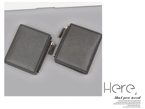 Close-up of black crossgrain leather wallets with gold-tone zippers and minimalist design
