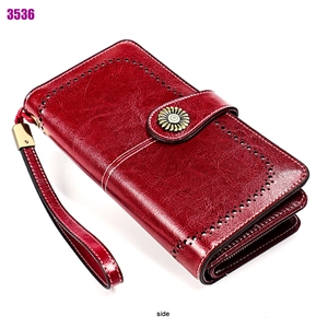 Détail du portefeuille long en cuir ciré rouge avec boucle tournesol et dragonne amovible