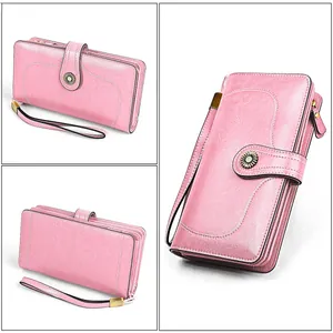 Détail du portefeuille long en cuir ciré rose avec boucle fleurie rétro et dragonne