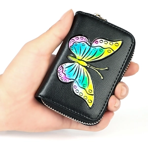 Handheld view of black leather credit card wallet with colorful butterfly relief design