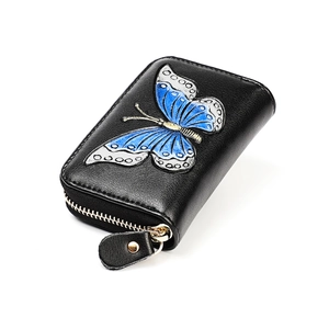 Close-up of genuine leather card holder with blue butterfly pattern and metal zipper detail