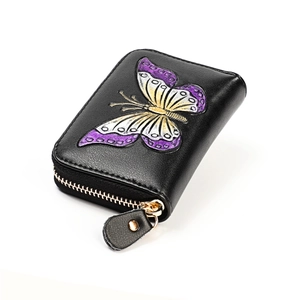 Detail of genuine leather card holder with embossed colorful butterfly and golden zipper