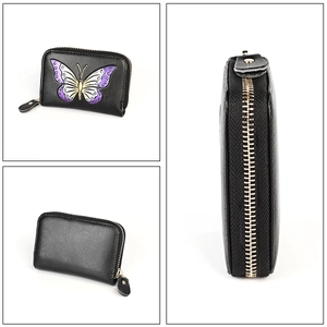Detail of a black leather card holder featuring a vibrant purple butterfly design