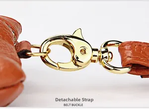 Detailed macro view of a gold-tone lobster clasp on orange-brown lychee grain leather