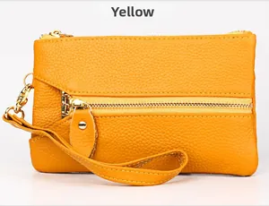 Detail of yellow lychee grain leather wallet with golden zipper and wrist strap