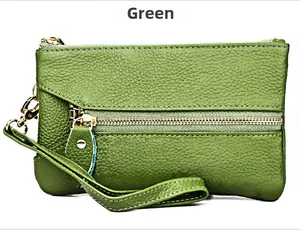 Detail of green litchi grain leather clutch with gold zipper and wristlet strap