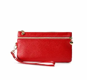Detail van rode leren clutch portemonnee met dubbele rits en hartvormige trekkers
