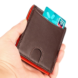 Detailed macro view of the slim brown leather wallet with orange lining and card slot