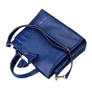 Macro shot of dark blue leather handbag showing lychee texture and crocodile embossing