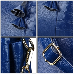 Detail of dark blue leather handbag with lychee and crocodile texture and gold hardware
