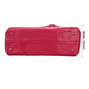 Detail van de bodem van de rozerode leren tas met gouden noppen en breedte van 125mm