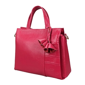 Detail of rose red leather handbag with lychee texture, crocodile pattern, and tassel
