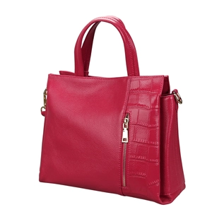Close-up of pink litchi leather texture and crocodile pattern stitching on handbag