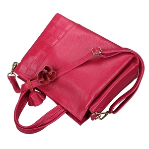 Detail of dark pink leather handbag featuring lychee and crocodile texture with flower charm