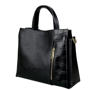 Detail of black leather handbag with lychee and crocodile texture and gold metal zipper