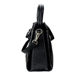 Detail view of black litchi grain leather texture and gold metal side hooks on the handbag
