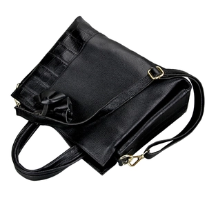 Close-up of black leather handbag with litchi grain and crocodile texture details