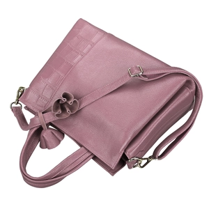 Detail of dusty rose leather handbag with lychee and crocodile texture and floral charm