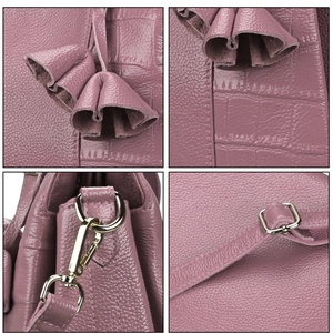Macro view of purple lychee and crocodile texture leather with gold metal hardware